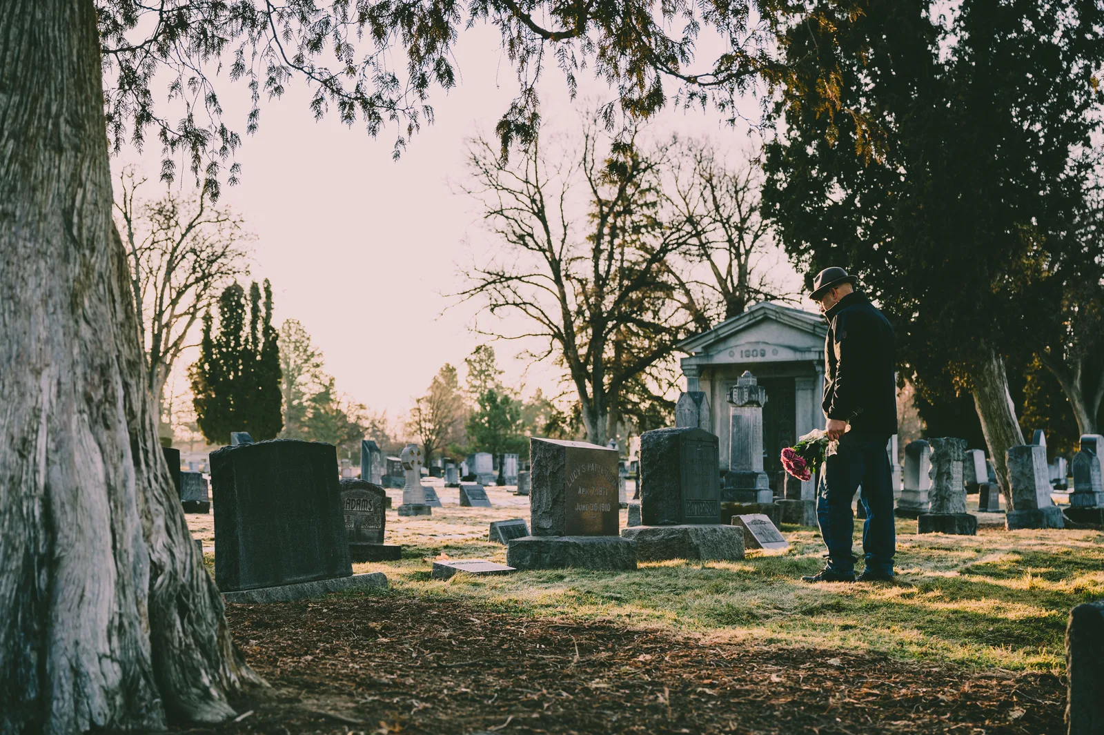 A person stands in a peaceful cemetery holding flowers in remembrance. National Center for Health Statistics death records